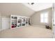 Bright bonus room offering carpet flooring and custom built-in shelving at 188 Lilac Mist Loop, Mooresville, NC 28115