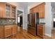 Kitchen featuring stainless steel refrigerator and wooden cabinets, and stone countertops at 188 Lilac Mist Loop, Mooresville, NC 28115