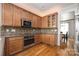 Cozy kitchen area features wood cabinets, stainless steel appliances, and stylish backsplash at 188 Lilac Mist Loop, Mooresville, NC 28115