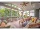 This is a screened porch with neutral furnishings and a view of the landscaped back yard and neighboring houses at 188 Lilac Mist Loop, Mooresville, NC 28115