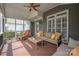 This is a screened porch with a wooden ceiling fan, a sofa with accent pillows, and a wooden coffee table at 188 Lilac Mist Loop, Mooresville, NC 28115