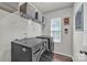 Functional laundry room with modern washer and dryer, shelving, and a window for natural light at 19455 Smith Cir, Cornelius, NC 28031