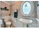 Small bathroom featuring unique oval window, wainscoting, and neutral wallpaper at 200 W 14Th St, Salisbury, NC 28144