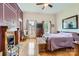 Comfortable bedroom featuring a fireplace, windows, wooden furniture, and a ceiling fan at 200 W 14Th St, Salisbury, NC 28144