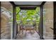A charming balcony with a table and chairs overlooks a serene garden view at 201 N Dotger Ave # C8, Charlotte, NC 28207