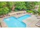 Inviting community pool with lounge chairs and tables surrounded by mature trees and landscaping at 201 N Dotger Ave # C8, Charlotte, NC 28207