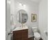 Modern half bathroom featuring a floating vanity with a vessel sink, round mirror and toilet at 2034 Houle Ln, Charlotte, NC 28214