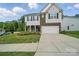 Charming two-story home featuring a brick and siding facade, landscaped front yard, and a two-car garage at 2034 Houle Ln, Charlotte, NC 28214