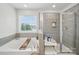 Bright bathroom featuring large bathtub, standup shower, and large window at 2034 Houle Ln, Charlotte, NC 28214