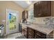 Galley style kitchen with stainless steel sink, granite countertops, tile backsplash, and access to outdoor patio at 209 Mcfadden St, Rock Hill, SC 29730