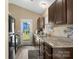 Galley style kitchen with stainless steel sink, granite countertops, tile backsplash, and access to outdoor patio at 209 Mcfadden St, Rock Hill, SC 29730