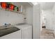 A laundry room with a washer and dryer, shelving and leads to the hallway and bathroom at 209 Mcfadden St, Rock Hill, SC 29730