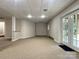 Unfinished basement featuring bright lighting, neutral carpeting, and glass doors to the outside at 228 31St Avenue Ne Ct, Hickory, NC 28601