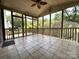 Inviting screened porch with tile flooring, ceiling fan, and scenic views of the lush backyard at 228 31St Avenue Ne Ct, Hickory, NC 28601