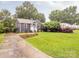 Lovely home has mature trees, green grass, and a concrete driveway leading to the light blue front door at 2421 Morton St, Charlotte, NC 28208