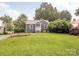 Charming home boasts beautiful landscaping, a well-maintained lawn, and a welcoming light blue front door at 2421 Morton St, Charlotte, NC 28208
