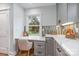 Modern kitchen boasts a built-in desk, white countertops, and ample cabinet space with wood flooring at 2421 Morton St, Charlotte, NC 28208