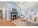 Inviting living room features a fireplace, wood floors, light blue walls, and vaulted ceilings at 2421 Morton St, Charlotte, NC 28208
