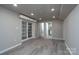 Open basement area with gray walls, wood-look floors, and two doorways leading to other rooms at 2617 Shady Lane Ave, Concord, NC 28027