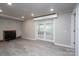 Open basement area with a fireplace, gray walls, wood-look floors, and a double glass door leading to outside at 2617 Shady Lane Ave, Concord, NC 28027