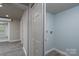 Hallway with gray plank flooring, white doors, and a glimpse into a laundry room at 2617 Shady Lane Ave, Concord, NC 28027