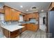 Stylish kitchen featuring granite counters, stainless appliances, wood cabinets, and a modern backsplash with bright lighting at 2617 Shady Lane Ave, Concord, NC 28027