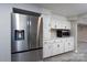 Stainless steel refrigerator and white cabinets and countertops in the basement kitchenette at 2617 Shady Lane Ave, Concord, NC 28027