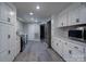 Kitchenette with white cabinets, gray countertops, stainless steel appliances, and gray wood-look flooring at 2617 Shady Lane Ave, Concord, NC 28027