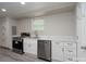 Basement kitchenette area with white cabinets and countertops, stainless steel appliances, and a window at 2617 Shady Lane Ave, Concord, NC 28027