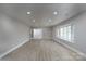 Inviting living room showcasing luxury vinyl floors, ample lighting, and French doors leading to another living space at 2617 Shady Lane Ave, Concord, NC 28027
