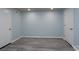 Spacious room featuring gray plank flooring, light blue walls, and two white doors at 2617 Shady Lane Ave, Concord, NC 28027