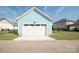 Detached blue garage with a white door, offering ample parking and storage space at 282 Auburn View Rd, Rock Hill, SC 29730