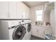 A bright laundry room features modern washer and dryer, white cabinets, and a sink at 282 Auburn View Rd, Rock Hill, SC 29730