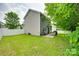 Back exterior of home with a stone patio and lush green grass, surrounded by a white picket fence at 288 Sand Paver Way # 50, Fort Mill, SC 29708