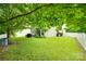 Spacious backyard with lush green grass, mature trees, and a white picket fence for privacy at 288 Sand Paver Way # 50, Fort Mill, SC 29708