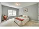 Well-lit bedroom with rocking chair, neutral walls, and a comfy bed, creating a relaxing retreat at 288 Sand Paver Way # 50, Fort Mill, SC 29708