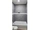 Well-lit bathroom with a bathtub and a shower featuring sleek gray tiling and modern fixtures at 306 E Ratchford Ave, Gastonia, NC 28054