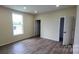 Bright bedroom with wood-look flooring and a large window offering ample natural light at 306 E Ratchford Ave, Gastonia, NC 28054