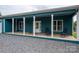 Exterior view of a teal home with a covered porch, columns, and gravel driveway at 3103 Richview Dr, Crouse, NC 28033