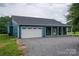 Charming teal home featuring a spacious two-car garage and a welcoming covered front porch with stone gravel at 3103 Richview Dr, Crouse, NC 28033