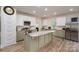 This kitchen showcases an island, stainless steel appliances, and white and sage-green cabinets at 3103 Richview Dr, Crouse, NC 28033