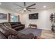 Cozy living room with large gray area rug, tv, modern fan and brown leather sectional sofa at 3103 Richview Dr, Crouse, NC 28033