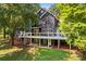 Exterior rear view of a two-story house with multilevel deck, patio and mature trees at 315 Wood Duck Loop, Mooresville, NC 28117