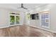Living room features hardwood floors, a ceiling fan, a tv, and access to the deck at 315 Wood Duck Loop, Mooresville, NC 28117