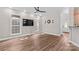 Bright living room featuring beautiful wood floors, modern ceiling fan, and abundant natural light from multiple windows at 315 Wood Duck Loop, Mooresville, NC 28117