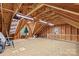 Upstairs garage loft space with exposed beams and a window providing natural light at 315 Wood Duck Loop, Mooresville, NC 28117