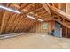 Unfinished upstairs garage loft space with exposed beams and a window providing natural light at 315 Wood Duck Loop, Mooresville, NC 28117