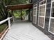Large outdoor deck with gray painted boards and view of mature trees, and covered patio area at 315 Wood Duck Loop, Mooresville, NC 28117