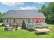 Wide view of backyard with deck, hammock, fire pit, manicured lawn, landscaping and mature trees at 320 Bluegill Ln, Statesville, NC 28625