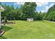 Expansive backyard with an outbuilding, deck, fire pit, mature trees and a lush lawn at 320 Bluegill Ln, Statesville, NC 28625